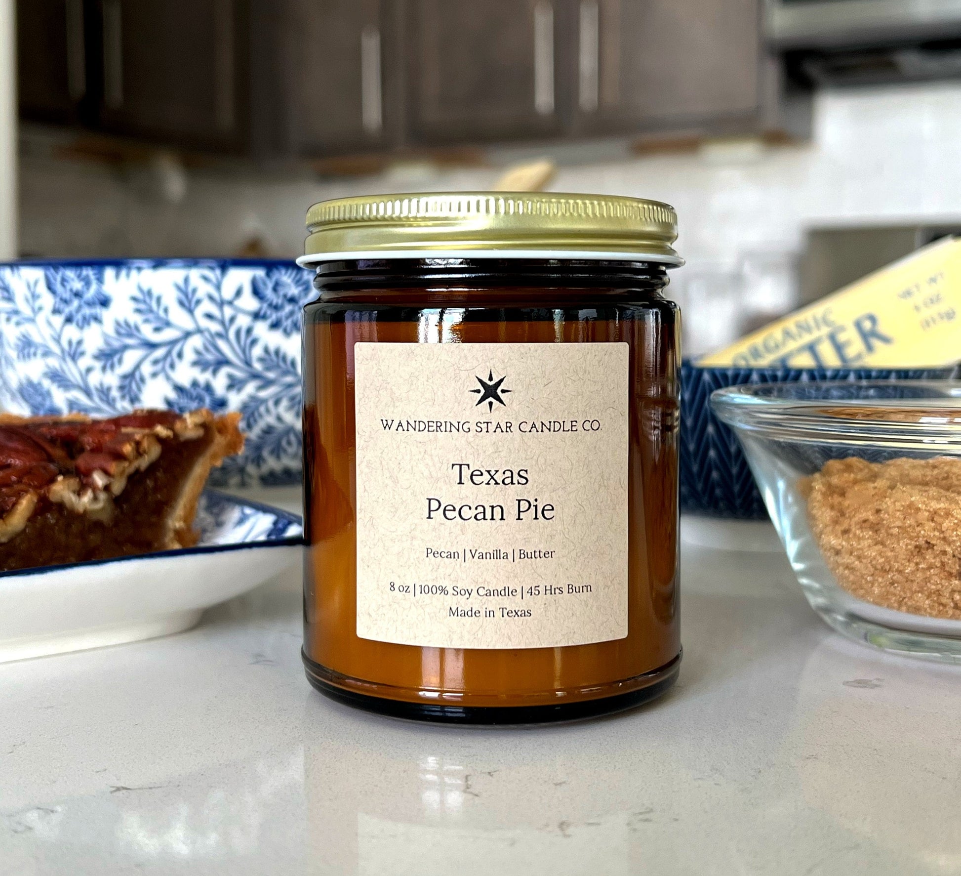 Photo of an amber jar candle with a gold lid in the scent of Texas Pecan Pie